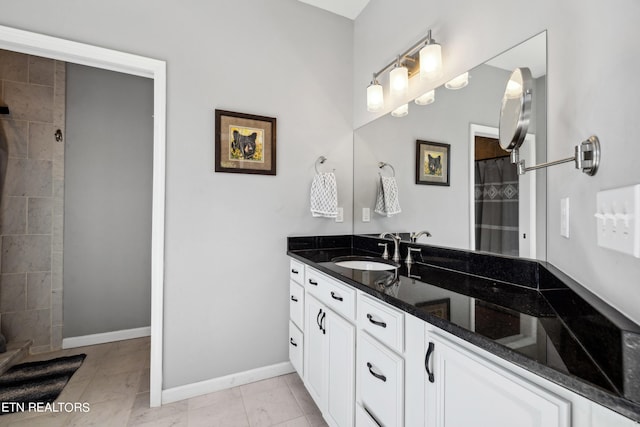 bathroom featuring vanity, tile patterned flooring, and tiled shower