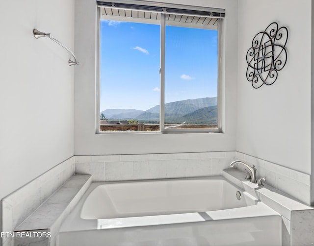 bathroom with a mountain view and a bathing tub