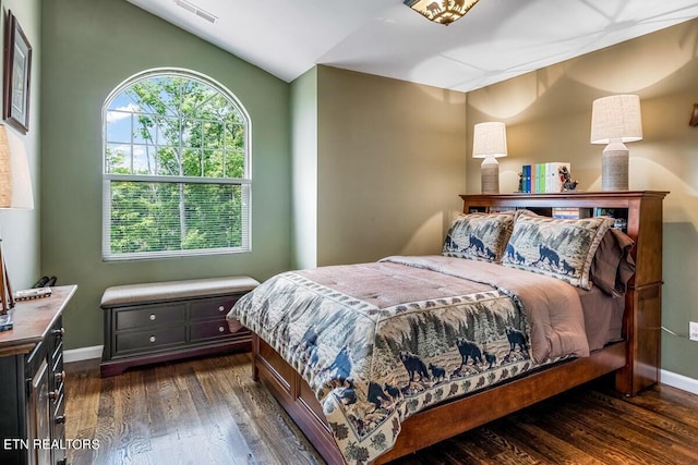 bedroom with vaulted ceiling and dark hardwood / wood-style floors