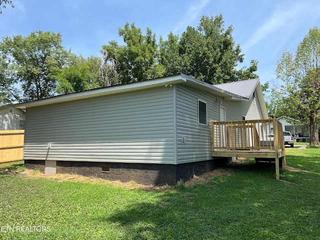 view of side of home featuring a yard and a deck