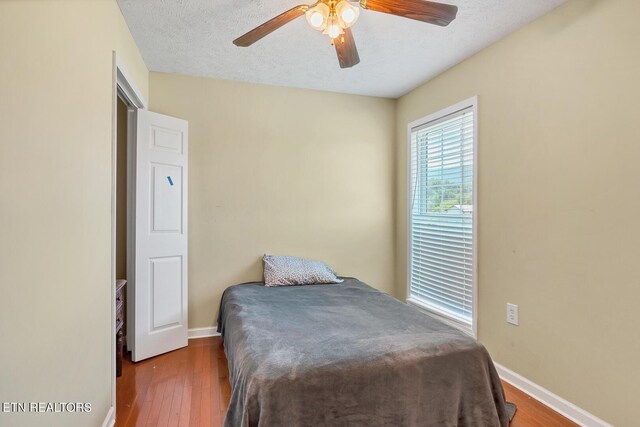 bedroom featuring a textured ceiling, wood-type flooring, and ceiling fan