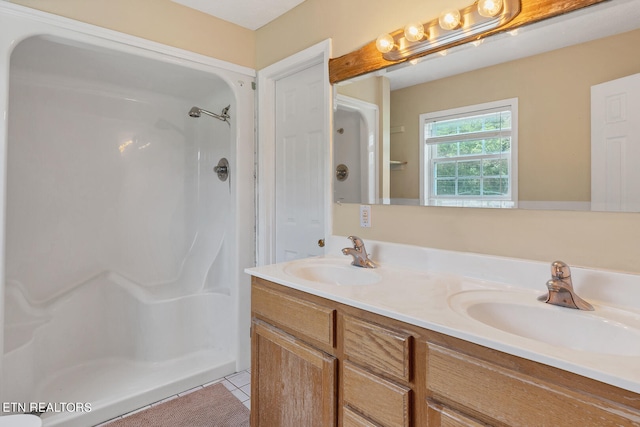 bathroom featuring dual vanity, tile patterned flooring, and a shower