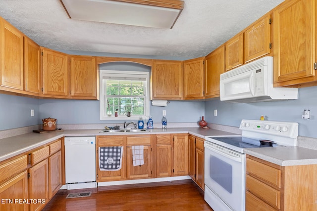 kitchen with sink, dark hardwood / wood-style flooring, a textured ceiling, and white appliances