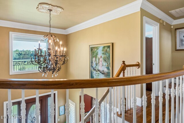 interior space with wood-type flooring, crown molding, and a chandelier