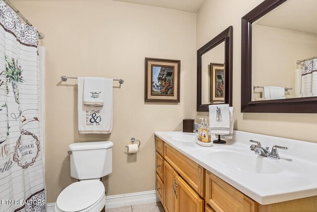 bathroom featuring dual vanity and toilet