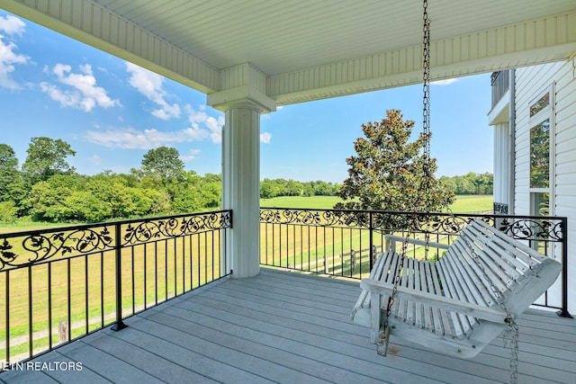 wooden terrace featuring a lawn