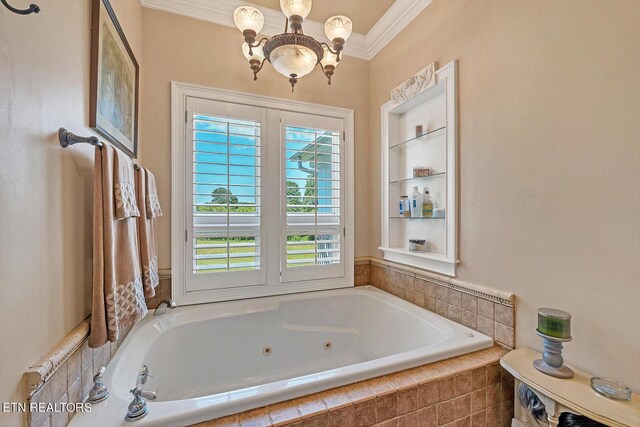 bathroom with tiled tub, crown molding, and a chandelier