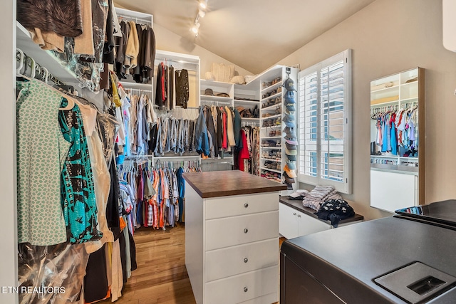 walk in closet with vaulted ceiling and light wood-type flooring