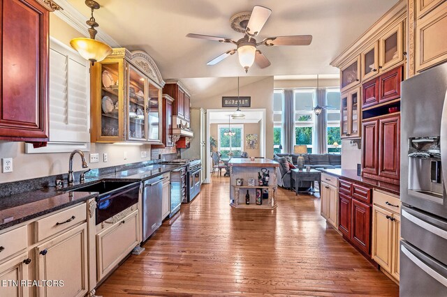 kitchen featuring dark stone countertops, pendant lighting, ceiling fan, appliances with stainless steel finishes, and hardwood / wood-style flooring