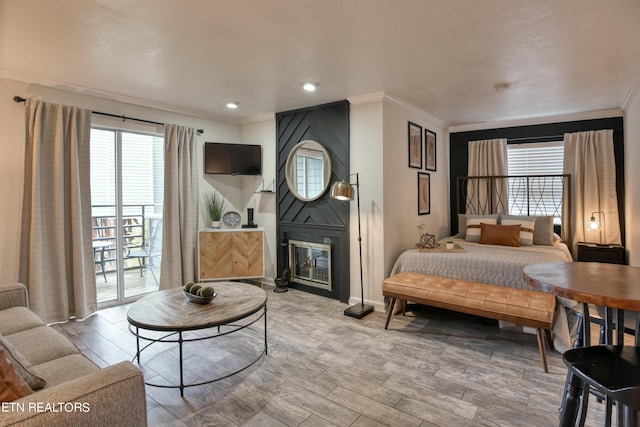 bedroom with access to exterior, a fireplace, and ornamental molding