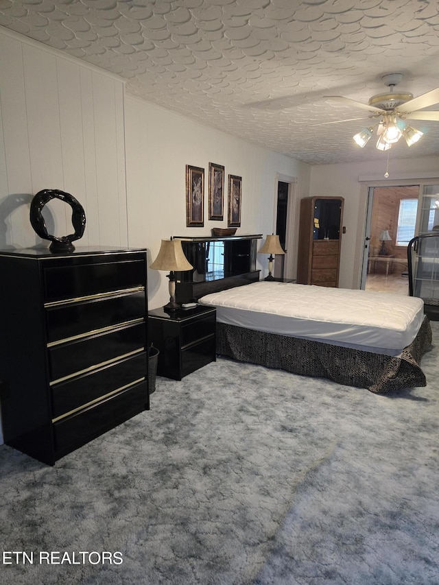 carpeted bedroom with ceiling fan and a textured ceiling