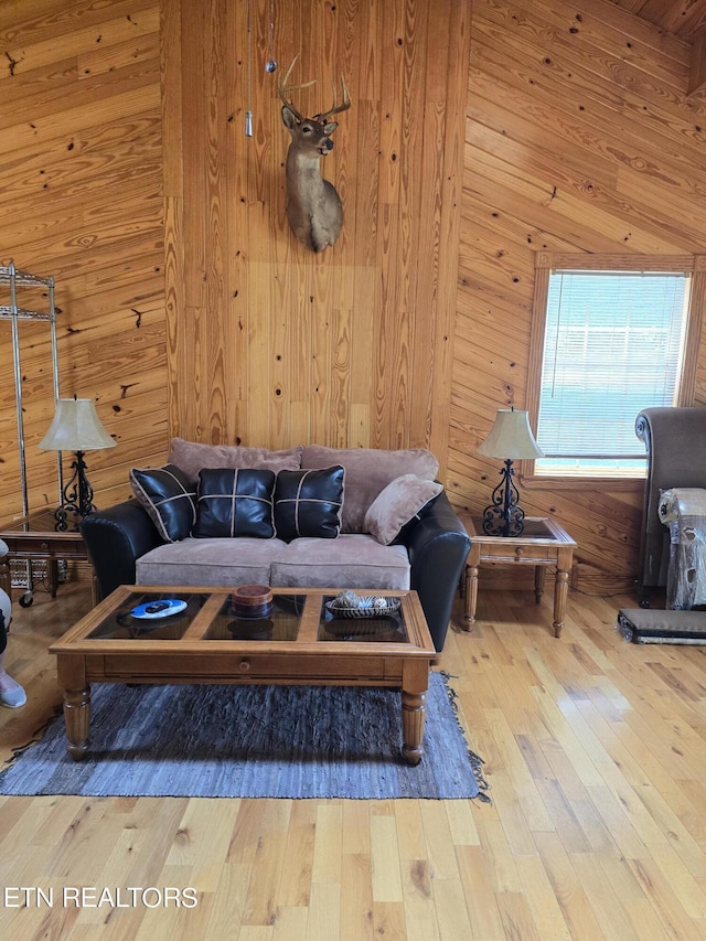 living room with hardwood / wood-style flooring and wooden walls