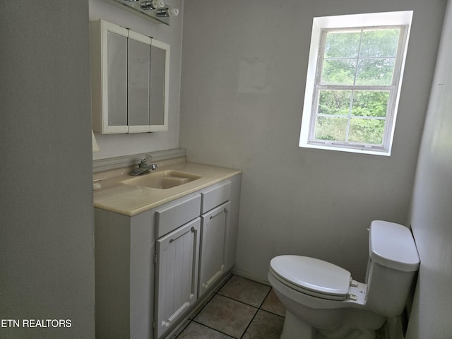 bathroom featuring tile patterned floors, vanity, a healthy amount of sunlight, and toilet