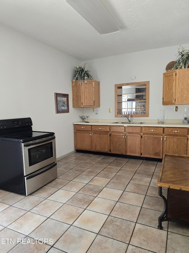 kitchen with light tile patterned flooring, stainless steel electric range oven, and sink