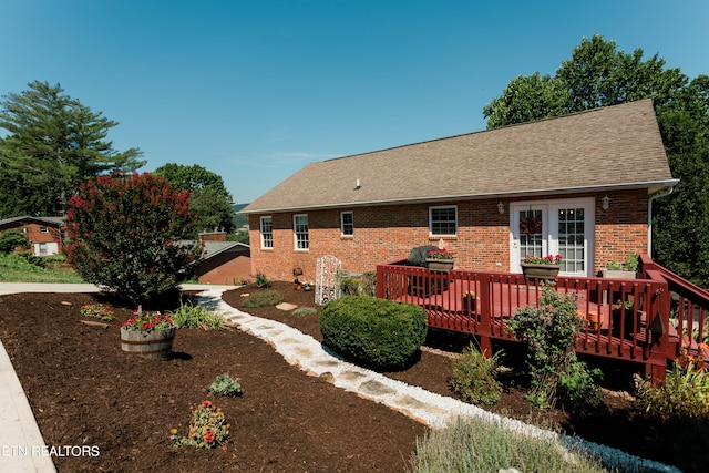 rear view of property featuring a wooden deck