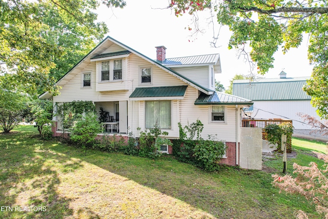 rear view of house featuring a lawn