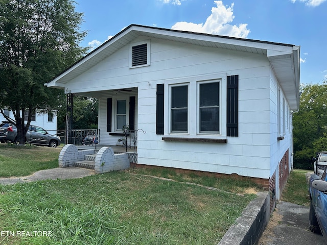 view of front of house featuring covered porch and a front lawn