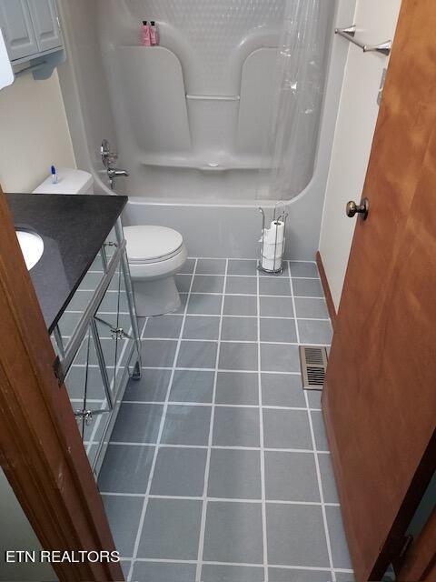 full bathroom featuring toilet, tile patterned floors, vanity, and shower / tub combo