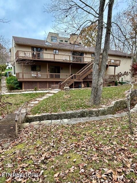 rear view of property with stairway and a wooden deck