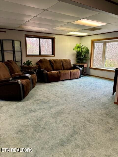 carpeted living room with a paneled ceiling and baseboards