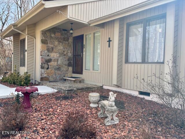 entrance to property with stone siding and crawl space