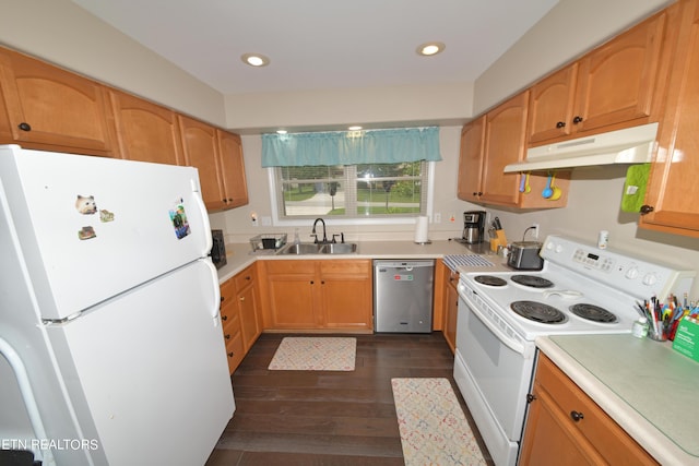 kitchen with dark wood-type flooring, white appliances, and sink