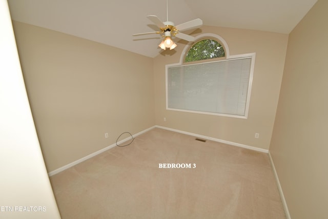 empty room with vaulted ceiling, light carpet, and ceiling fan