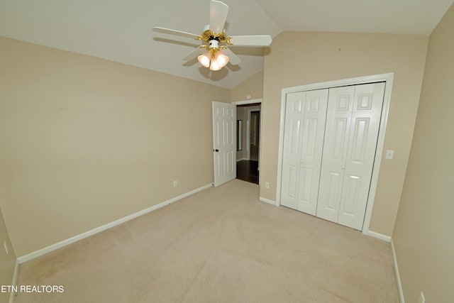 unfurnished bedroom with lofted ceiling, light colored carpet, a closet, and ceiling fan