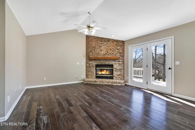 unfurnished living room featuring a brick fireplace, vaulted ceiling, dark hardwood / wood-style floors, and ceiling fan