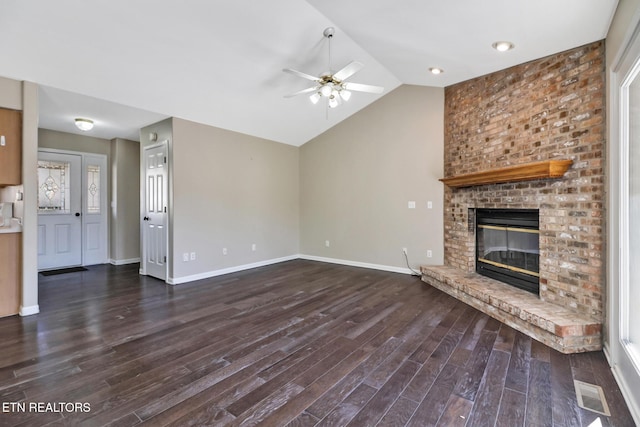 unfurnished living room with a brick fireplace, dark hardwood / wood-style floors, lofted ceiling, and ceiling fan