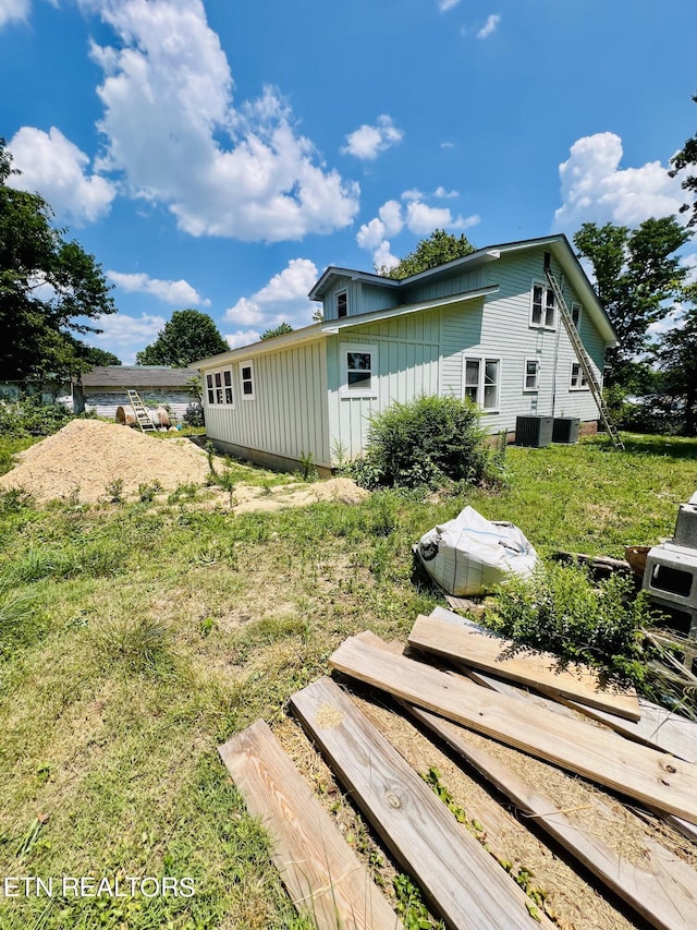 exterior space with a lawn and central AC