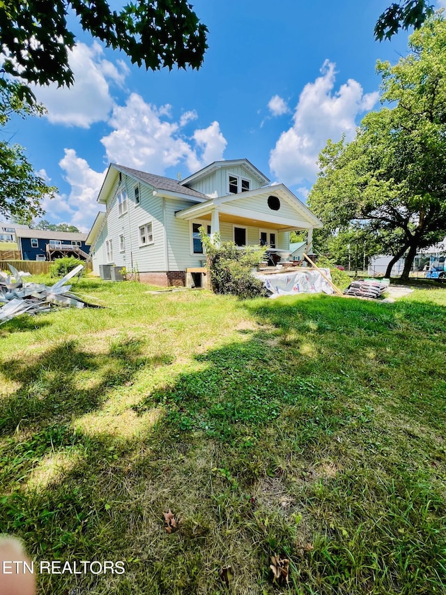 back of property with a lawn and central AC unit