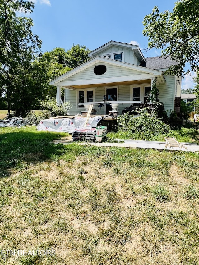 view of front of property with covered porch and a front yard