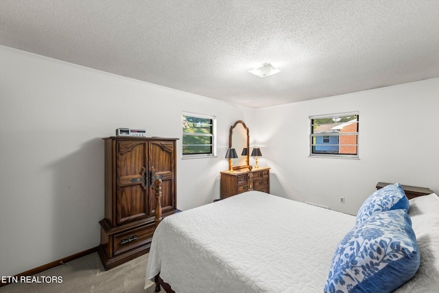 bedroom with light colored carpet and a textured ceiling