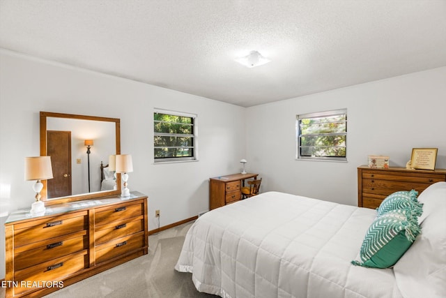 bedroom featuring light colored carpet and a textured ceiling