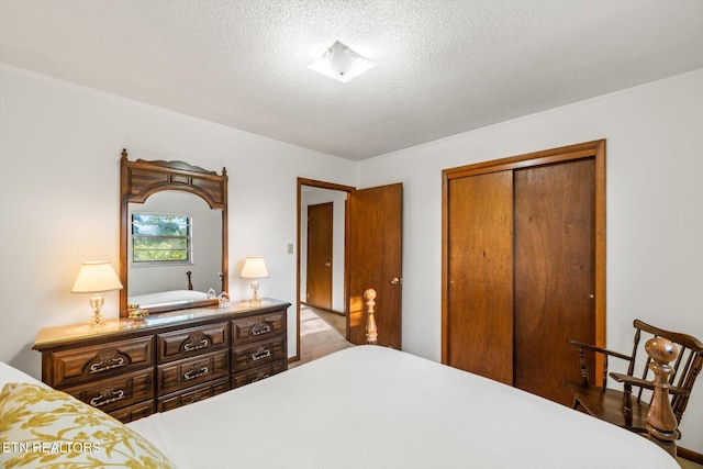 bedroom featuring a textured ceiling and a closet