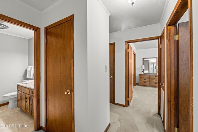 hallway featuring crown molding, light colored carpet, and a textured ceiling