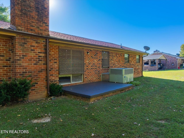 rear view of property featuring cooling unit, a yard, and a patio area