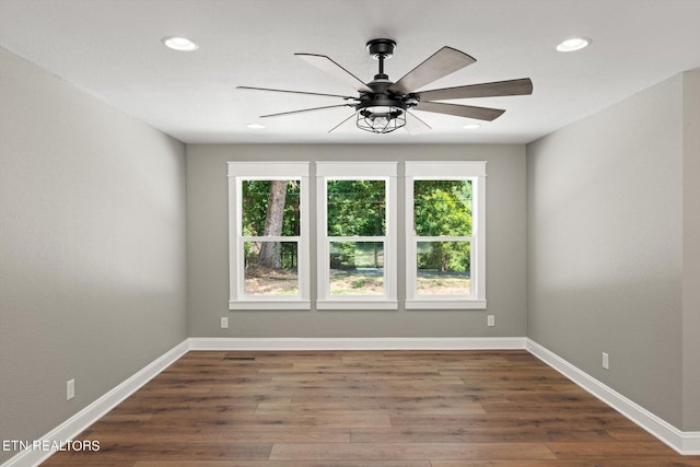 empty room featuring dark wood-type flooring and ceiling fan