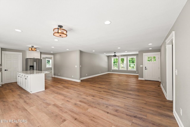 unfurnished living room with light hardwood / wood-style floors and ceiling fan