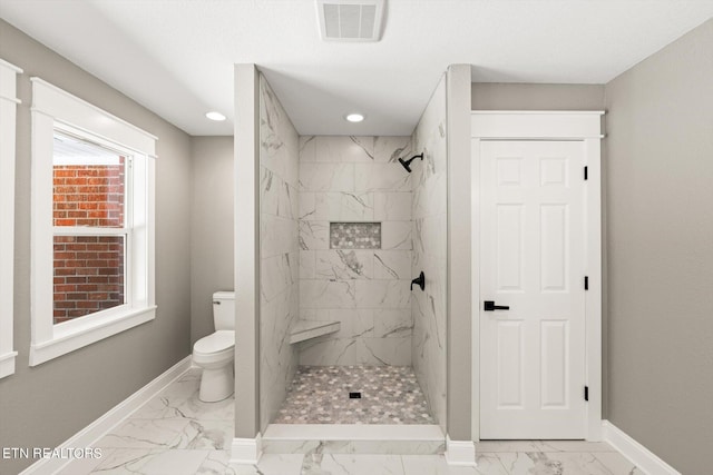 bathroom featuring toilet and tiled shower