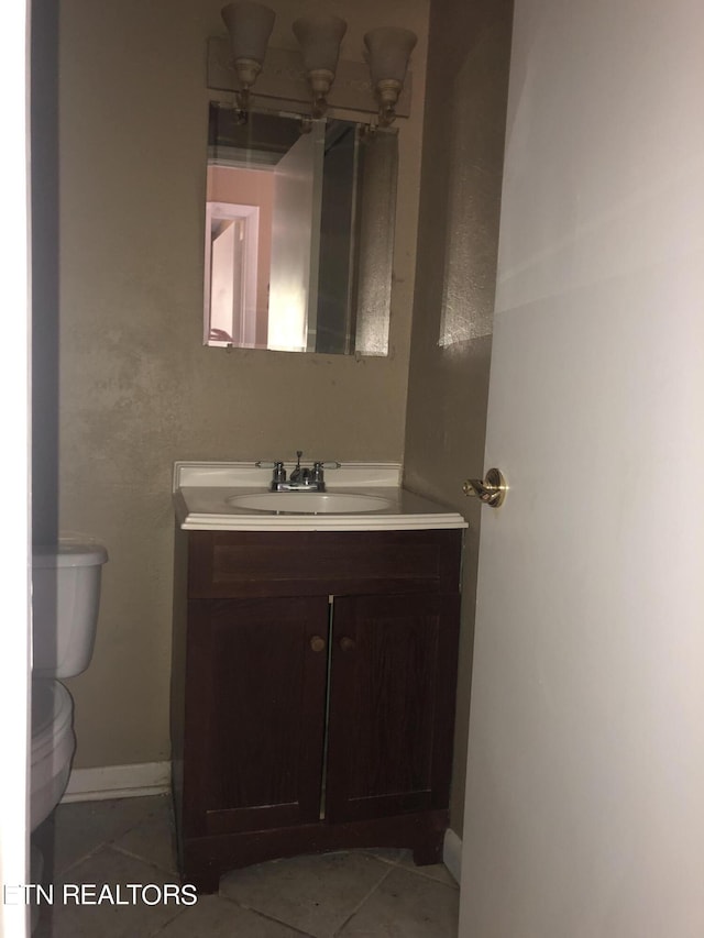 bathroom with tile patterned flooring, vanity, and toilet