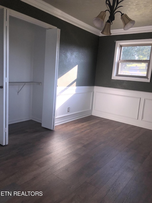 unfurnished bedroom featuring dark hardwood / wood-style flooring, a closet, and crown molding