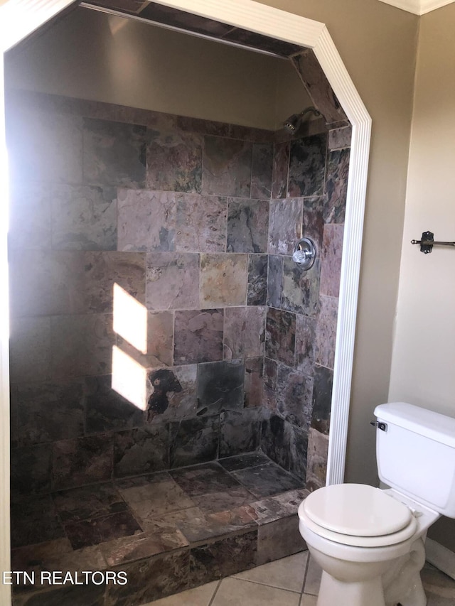 bathroom with tiled shower, tile patterned flooring, and toilet