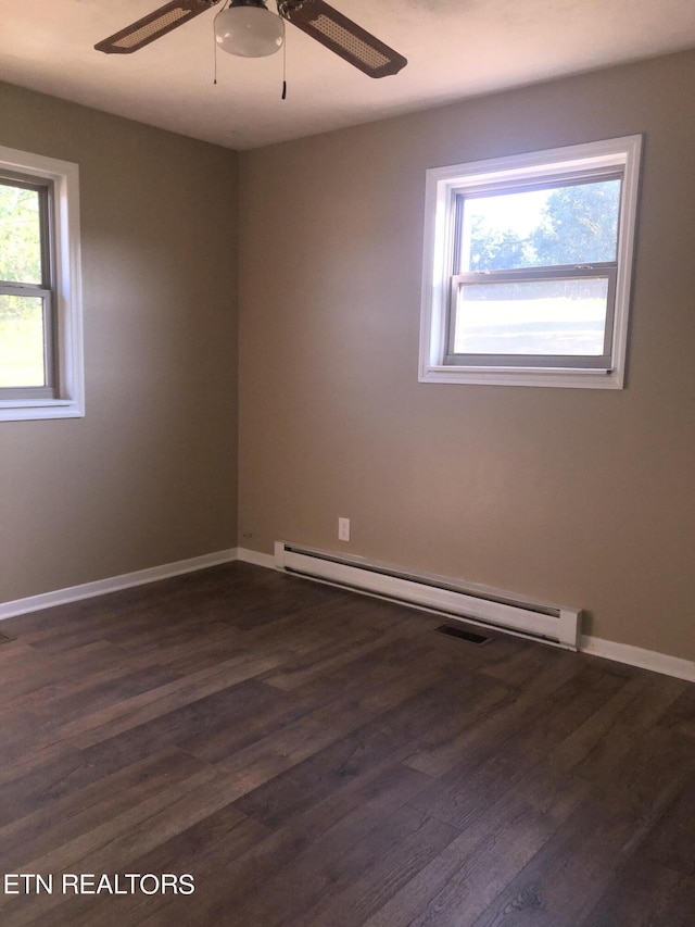 empty room with ceiling fan, plenty of natural light, a baseboard radiator, and dark hardwood / wood-style floors