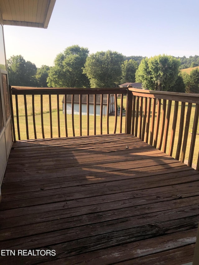 wooden terrace featuring a lawn