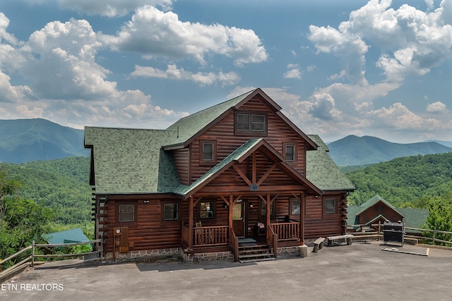 cabin with covered porch and a mountain view