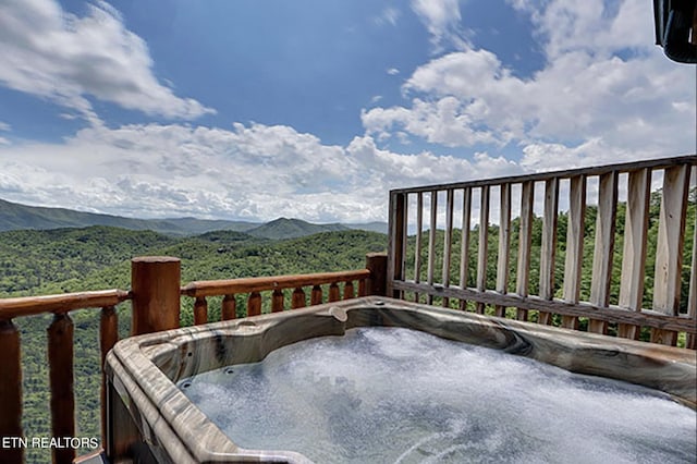 wooden terrace featuring a mountain view and a hot tub