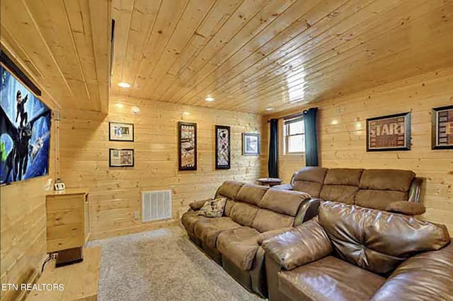 carpeted home theater room featuring wood ceiling and wooden walls