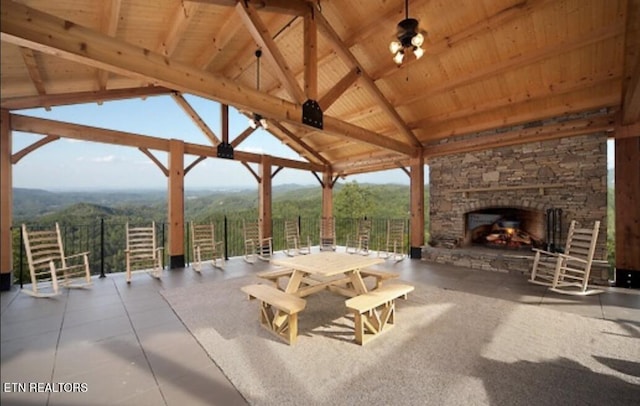 view of patio / terrace featuring a gazebo and an outdoor stone fireplace